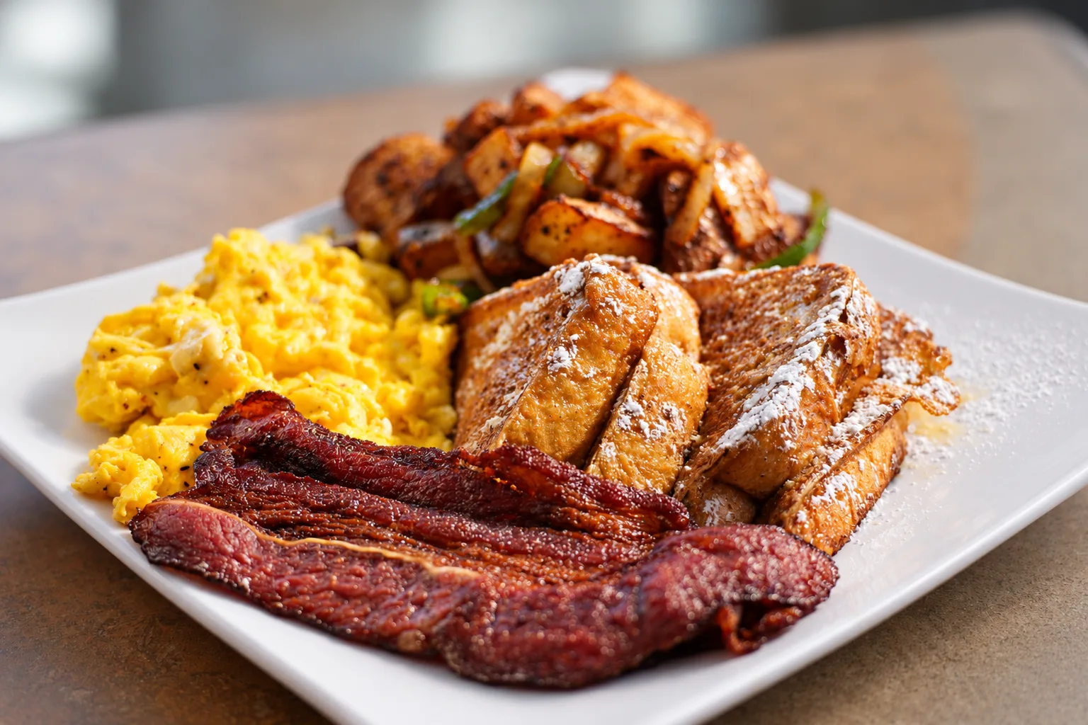 Breakfast plate with scrambled eggs, French toast and home fries